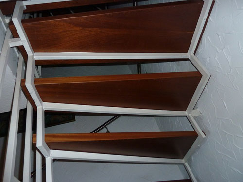 Opotřebené dřevěné stupně na kovové konstrukci před renovací